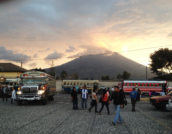 Chicken Bus terminal in Antigua under the looming Volcan de Agua, Guatemala -- April Beresford